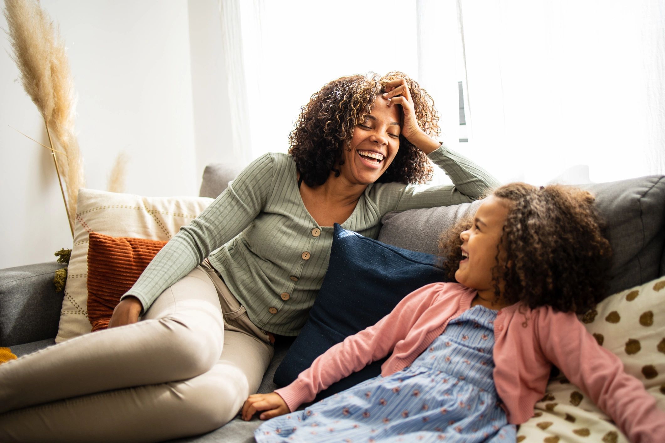 Mother and daughter laughing together in a living room