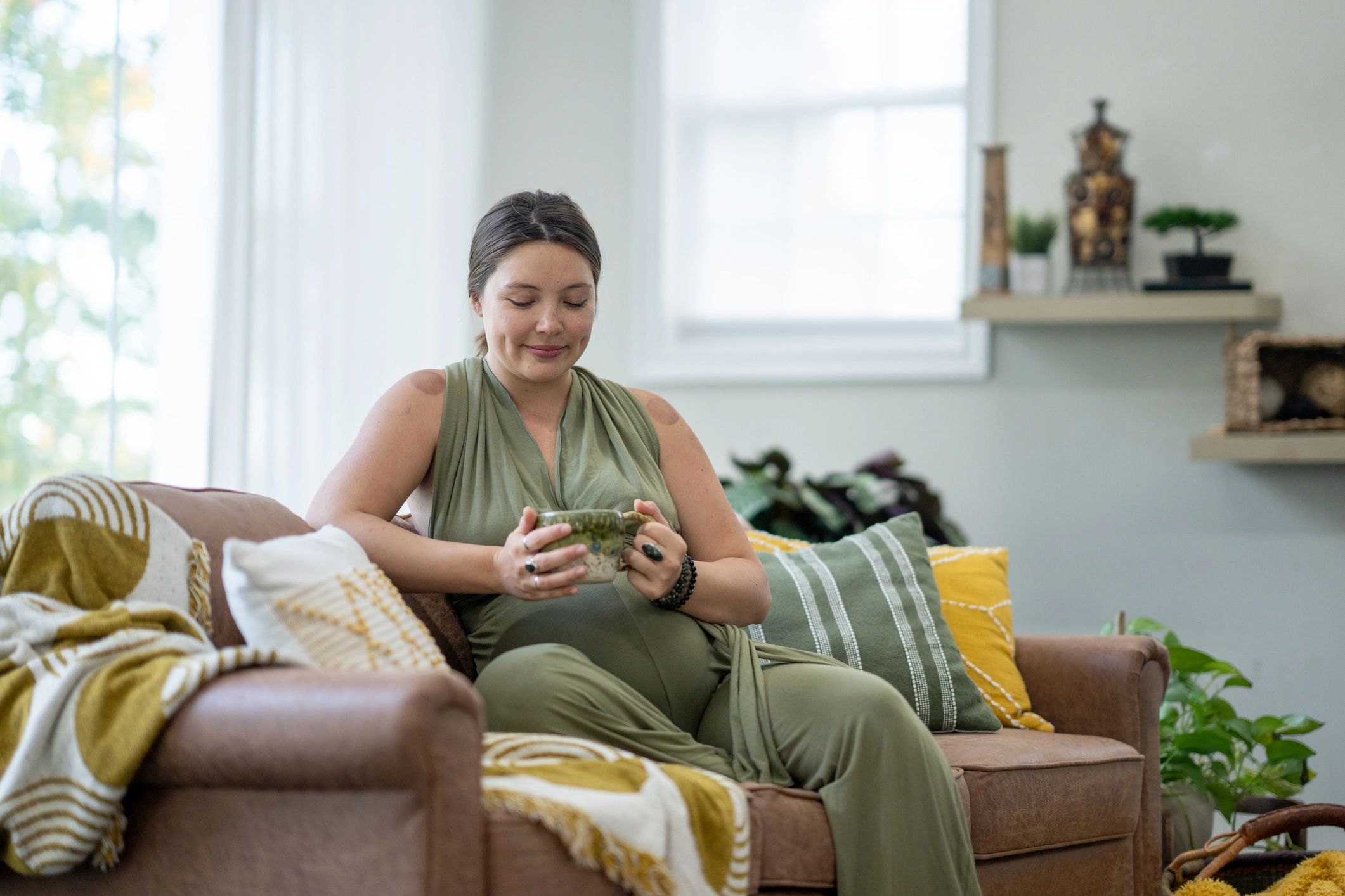 Mom relaxing with a cup of tea on the sofa
