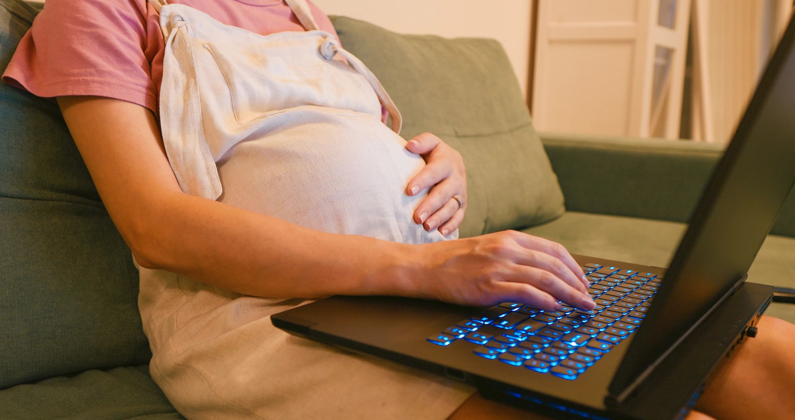 Hands typing on a laptop late at night